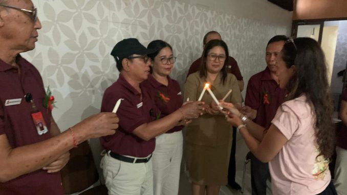 Penyalaan lilin yang dipegang Perbekel Desa Dauh Puri Klod oleh aktivis Ika Rayni serangkaian acara Malam Renungan AIDS Nusantara 2025- RFH