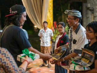 Made Bayak salah satu pembicara dan seniman yang terlibat dalam pembuatan Film Roots memberikan penghargaan kepada pemenang kompetisi resensi Film Roots (Foto Wayan Martino, Niskala Studio) - IST