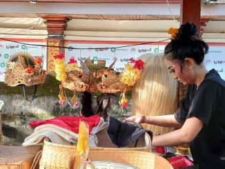 Menyiapkan mahkota. Gita (24) tengah menyiapkan mahkota untuk dikenakan saat tampil menari pada rekasadana (pergelaran) drama tari topeng. Ia bergabung dengan generasi Z lainnya bersama seniornya dari generasi milenial di Sanggar Genta Manik, Kabupaten Gianyar, Bali, sebagai penari. (KanalBali.id/Ayu Sulistyowati)