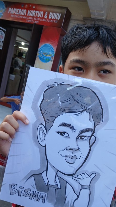 Hitam putih. Seorang anak senang dan memamerkan hitam putih sketsa kartun wajah hasil goresan Man Ata, Minggu (13/7/2025).