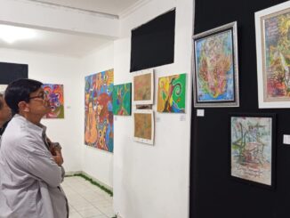 Pengamat sosial Putu Suasta menikmati karya yang dipamerkan di Rumah Berdaya, Denpasar - IST