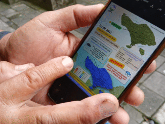 Pekaseh Subak Padanggalak, Kota Denpasar, Ketut Losen memperlihatkan whatsapp grup subaknya dari telepon genggam pintarnya mengenai informasi prakiraan cuaca dari BMKG Wilayah Denpasar, Jumat (13/2/2026). Informasi ini merupakan prakiraan cuaca setiap 10 harian (dasarian) dan membantunya beserta anggota subak mengambil keputusan untuk mengelola sawahnya kedepan. (Foto : KanalBali.id/Ayu Sulistyowati)