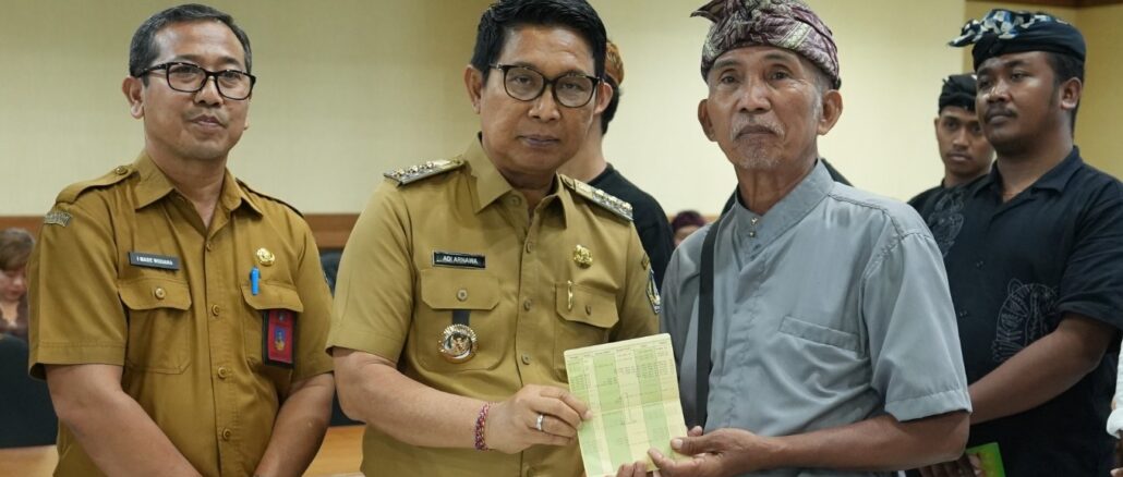 Bupati Adi Arnawa saat menyerahkan buku rekening tabungan kepada 26 Sekaa dan Komunitas Seni yang akan menjadi Duta Kabupaten Badung pada PKB XLVIII Tahun 2026, di Puspem Badung, Senin (13/4). --