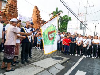 Bupati Wayan Adi Arnawa melepas peserta jalan santai dalam rangka HUT. Ke-27 Desa Cemagi di Kantor Perbekel Desa Cemagi, Minggu (26/7).- IST
