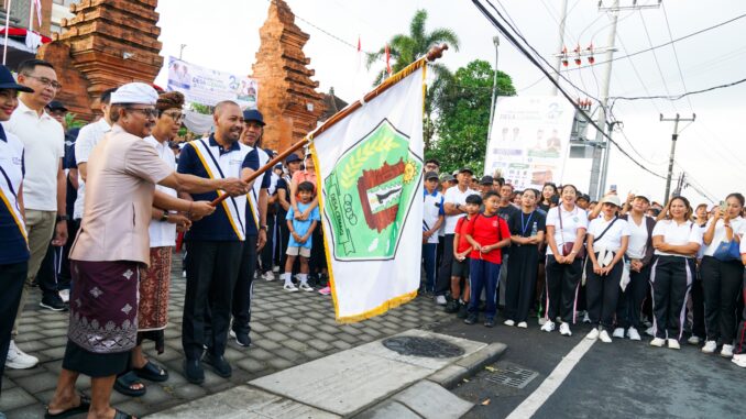 Bupati Wayan Adi Arnawa melepas peserta jalan santai dalam rangka HUT. Ke-27 Desa Cemagi di Kantor Perbekel Desa Cemagi, Minggu (26/7).- IST