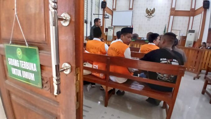 Para terdakwa (rompi oranye) kasus TPPO 21 ABK Awindo 2A, menunggu sidang di salah satu ruang Pengadilan Negeri Denpasar, 2 Juni 2026. (KanalBali.id/Ayu Sulistyowati)