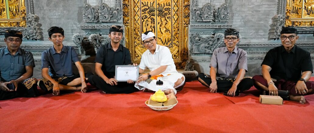 Bupati Wayan Adi Arnawa menyerahkan Piagam Penghargaan Tertib Administrasi Pengurusan Akta Kematian dan KK di Lingkungan Karang Suwung, Kelurahan Sading, Mengwi, Kamis (30/7) - IST