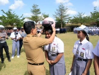 Bupati Adi Arnawa menyerahkan bantuan helm kepada perwakilan siswa-siswi SMA Negeri 2 Abiansemal serangkaian Peringatan Hari Perhubungan Nasional Ke-55 Tahun 2026 tingkat Kabupaten Badung, Senin (14/9).